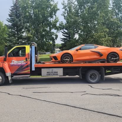 Dave's Towing flatbed truck towing a sports car in Diamond Valley